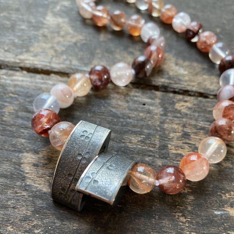 gemstone and Silver beaded necklace on a wooden background