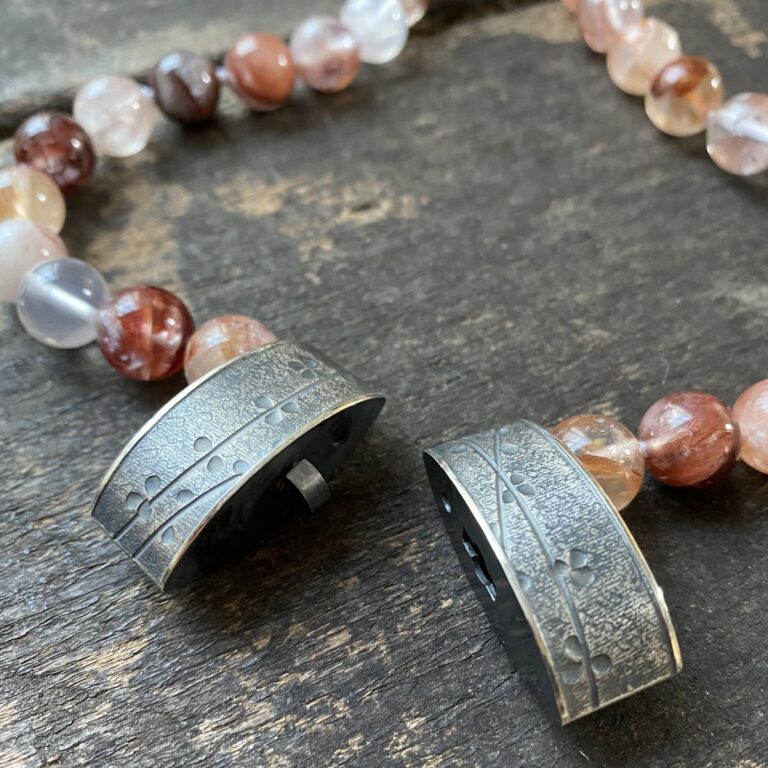 gemstone and Silver beaded necklace on a wooden background