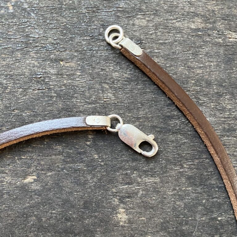 Silver pendant necklace on a wooden background