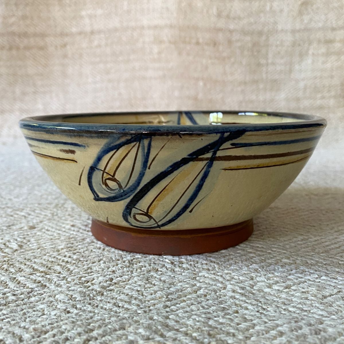 Jennifer Hall Cream Slipware bowl taken from the side, on a cream backcloth