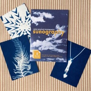 Cyanotype Sunography papers with examples on striped backcloth