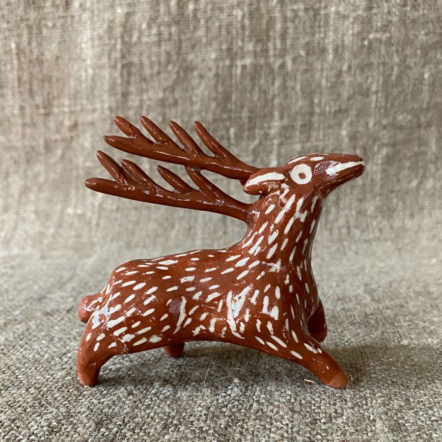 Emma Carlow pottery whistle in the shape of a reindeer against a cloth backdrop