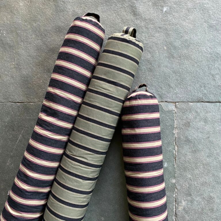 Trio of Striped Draught Excluders on a grey stone floor