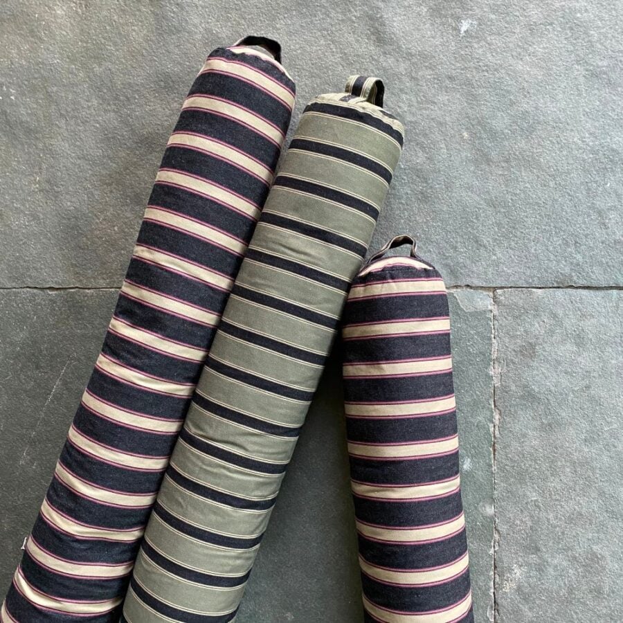 Trio of Striped Draught Excluders on a grey stone floor