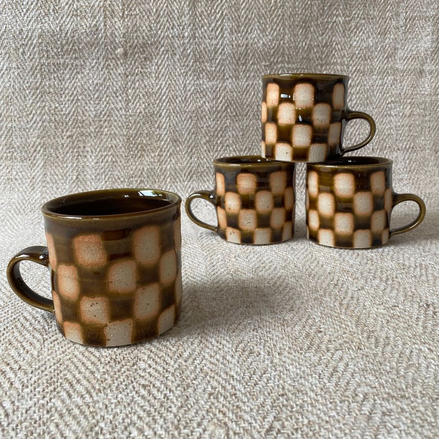 A striking mug with checked design by Norwich potter, Edmund Davies.