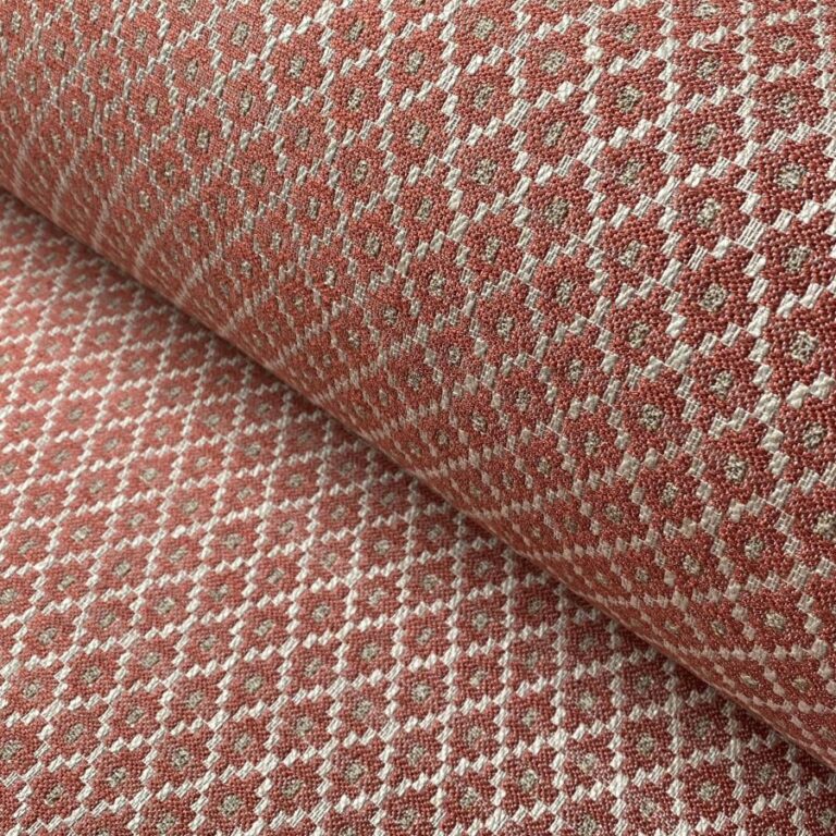 Brick red upholstery fabric with a small diamond shaped pattern in the weave
