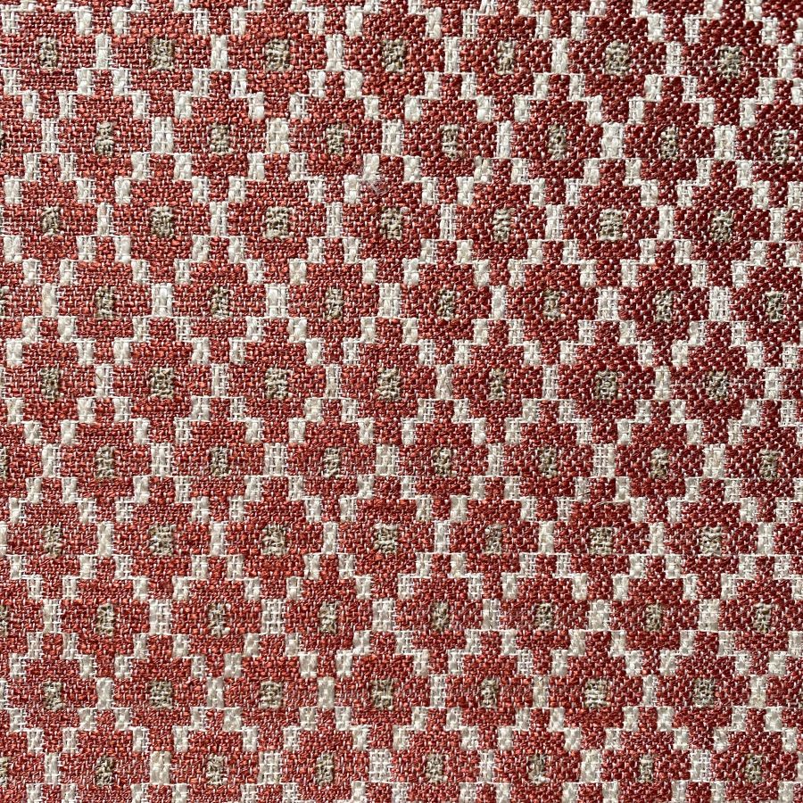 Brick red upholstery fabric with a small diamond shaped pattern in the weave
